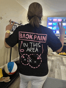 a woman wearing a black t-shirt that says " in this area "