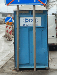 a blue portable toilet says dix on the front