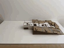 a cardboard model of a city sits on a white surface