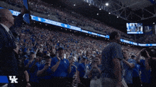 a man in a suit holds up a piece of paper in front of a crowd at a basketball game sponsored by pabst