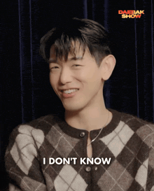 a man wearing a plaid sweater says i do n't know