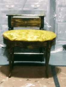 a small table with a yellow cushion sits next to a smaller table