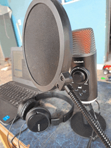 a pair of sony headphones sit next to a radiohead microphone