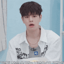 a young man wearing a white shirt that says no