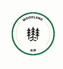 a logo for woodland air with three trees in a green circle