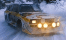 a yellow and black car is driving in the snow .