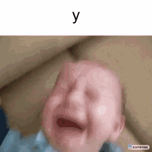 a baby is crying on a couch with the letter y above him .