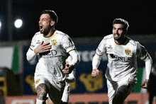 a group of soccer players are running on a field .