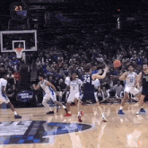 a basketball game is being played in front of a crowd with a banner that says mercy madness