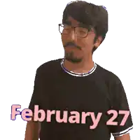 a man wearing glasses and a black shirt with february 27 written on it