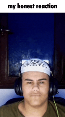 a man wearing headphones and a white hat with the words my honest reaction on the bottom