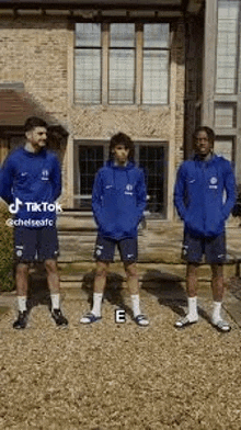 a group of soccer players are standing in front of a building .