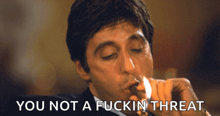 a man lighting a cigarette with the words you not a fuckin threat