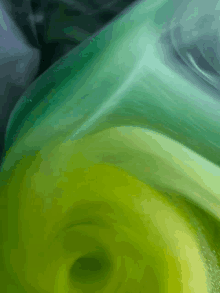 a close up of a green and blue liquid with a swirl in the middle