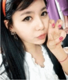 a young woman with long black hair is taking a selfie with her hand on her face .