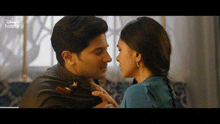 a man and a woman are kissing in front of a window in a room .