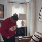 a woman in a red sweater that says the b on it
