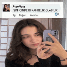 a girl taking a picture of herself in a mirror with a message from roseheus behind her