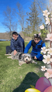 a man wearing a us polo assn jacket sits next to a boy and a dog