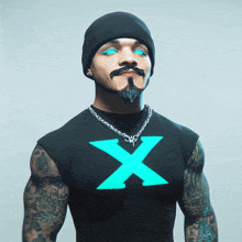 a man with a beard and blue eyes wears a black shirt with an x on it