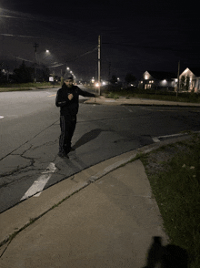 a man is standing on the sidewalk in front of an intersection with a sign that says ' a ' on it