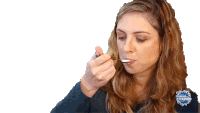 a woman is eating something with a spoon and the word mundo is on the bottom left