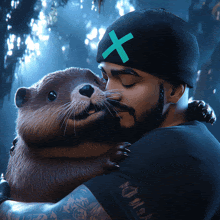 a man wearing a black hat with a green x on it is hugging a otter