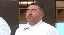 a man wearing a white chef 's jacket is looking at something