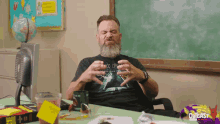 a man with a beard sits at a desk in front of a chalkboard with the word quicast on it