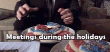 a man in a suit is sitting at a table with a plate of cookies and the words meetings during the holidays above him