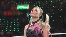 a woman in a pink and purple outfit is waving