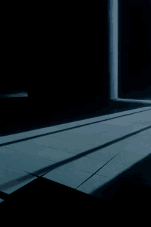 a dark room with a blue pillar and a shadow on the floor