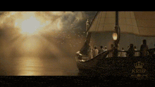 a group of people are on a boat in the water with krhf written on the bottom of the screen