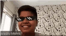 a young boy wearing sunglasses is smiling in a room .