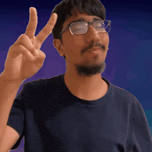 a man with glasses and a beard giving the peace sign
