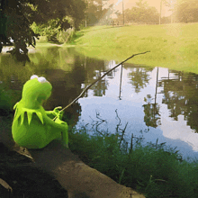 kermit the frog is fishing in a pond with a fishing rod