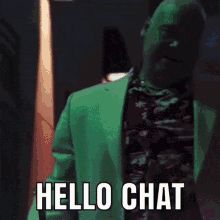 a man in a green suit is talking on a cell phone and says hello chat .