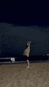 a person standing on a beach with their arms outstretched