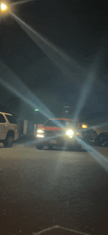 a car with a license plate that says ' ambulance ' on it drives down a street at night