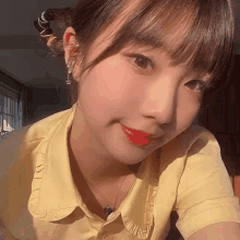 a young girl wearing a yellow shirt and red lipstick