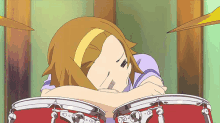 a girl laying on top of a drum set with a yellow headband