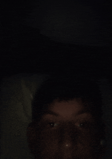 a man 's face is visible in the dark