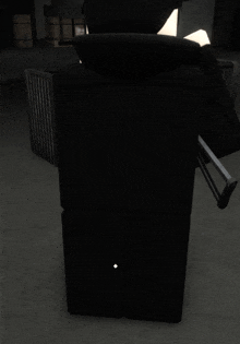 a black chair in a dark room with a white diamond in the corner