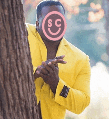 a man in a yellow suit has a pink smiley face on his face