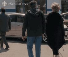 a group of people are walking down a street with #schitts creek written on the bottom