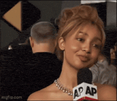 a woman wearing a necklace and a microphone that says ap on it