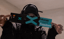 a person holding a wallet and a sign that says money meets freedom