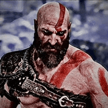 a bald man with a beard and red paint on his face .