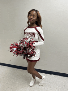 a cheerleader for the maroon tigers holds a pom pom