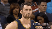 a basketball player stands in front of a crowd watching a game between the cleveland cavaliers and the denver nuggets